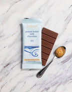 Peanut butter milk chocolate bar and packaging on a marble surface