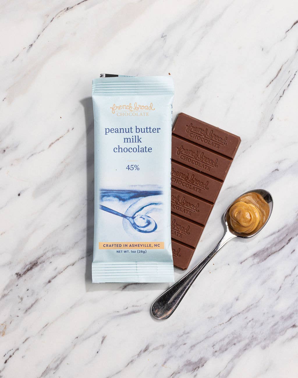 Peanut butter milk chocolate bar and packaging on a marble surface