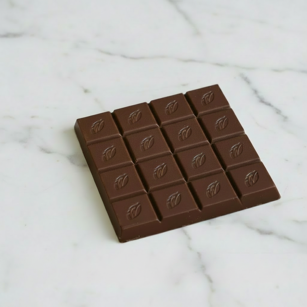 Willie's Cacao Milk of the Stars 54% Milk Chocolate bar unwrapped on white marble showing embossed Willie's Cacao squares, soft caramel notes from Surabaya Java Indonesia