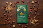 70% Cacao Adventures Dark Chocolate Bar with cacao beans and coconut sugar around it.