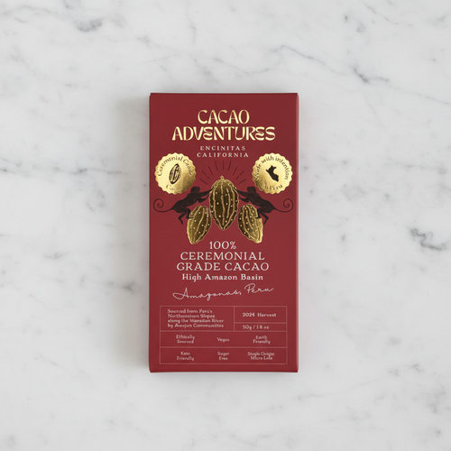 Cacao Adventures 100% Ceremonial Grade Cacao Bar red box on white marble surface, single-origin High Amazon Peru, vegan sugar-free keto-friendly, 50g