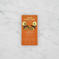 Cacao Adventures Unmilk'd Chocolate 53% cacao bar with Lucuma on white marble surface, dairy-free vegan keto-friendly, single-origin Peru