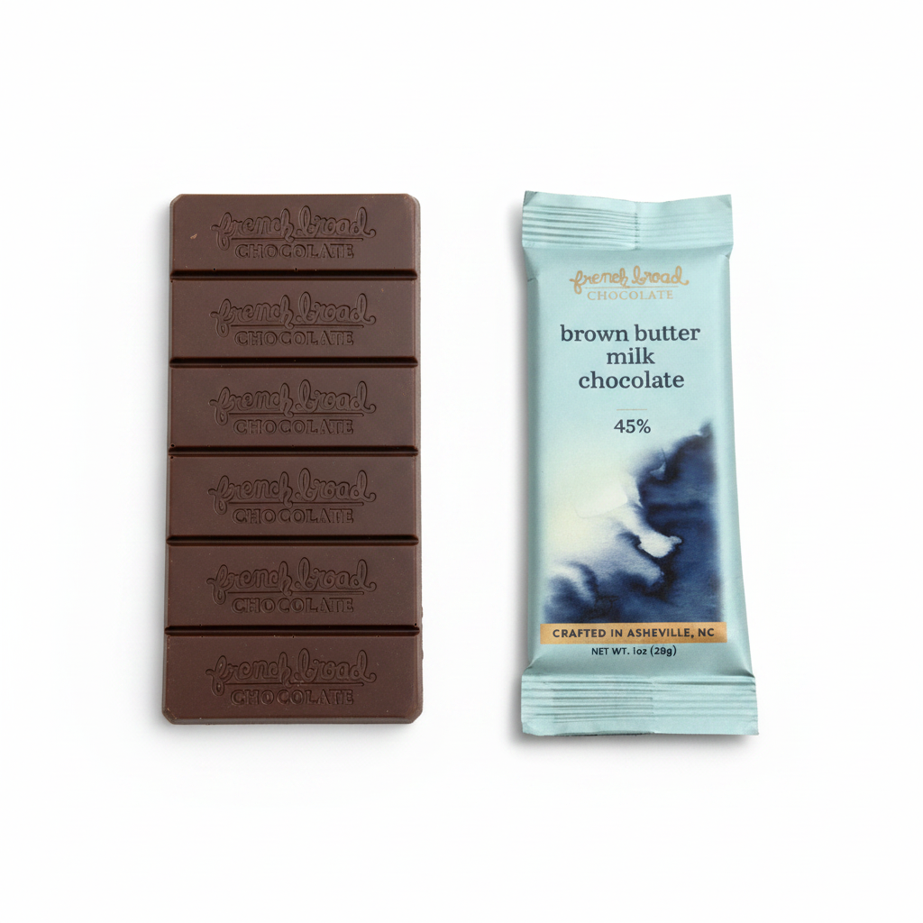 French Broad Chocolate 45% Brown Butter Milk Chocolate light blue packaging and embossed chocolate bar on clean white background, crafted in Asheville NC