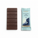 French Broad Chocolate 45% Brown Butter Milk Chocolate light blue packaging and embossed chocolate bar on clean white background, crafted in Asheville NC