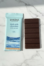 French Broad Chocolate 53% Dark Milk Chocolate Bar with Sea Salt packaging and chocolate bar on marble background, gluten-free nut-free