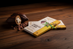 Mahogany Chocolate Blanco white chocolate bar with open cacao pod and beans on dark rustic hardwood surface