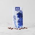 Nomé 73% Chocolate Oscuro bar with white packaging and deep blue botanical watercolor illustration on white marble, single-origin Panama, vegan dairy-free, 45g
