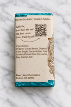 Back of the El Camino dark chocolate bar from River Sea Chocolates, showing the ingredients and QR code on a white marble background.