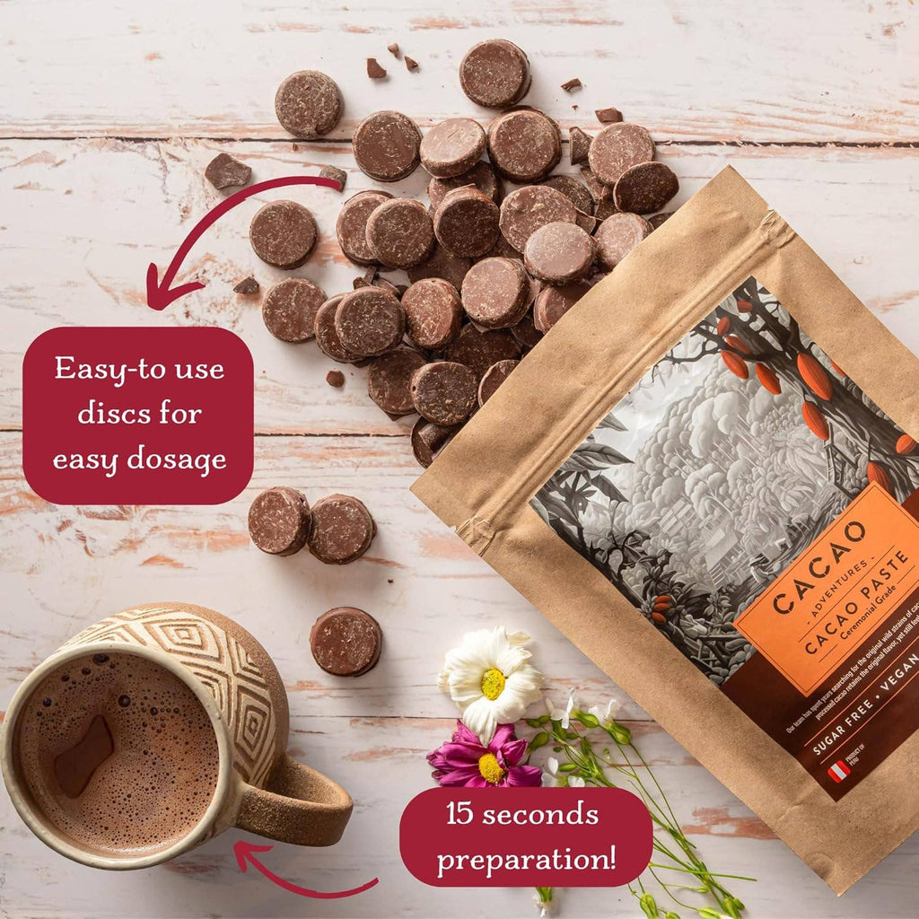Cacao paste packaging with chocolate discs and a mug on a wooden surface