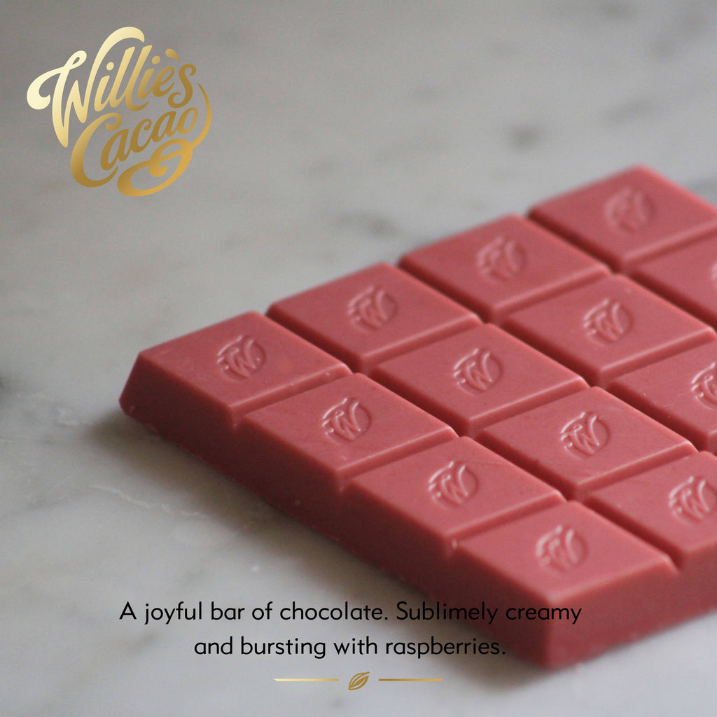Raspberries & Cream unwrapped. Pink white chocolate bar with 'Willie's Cacao' branding on a marble surface 