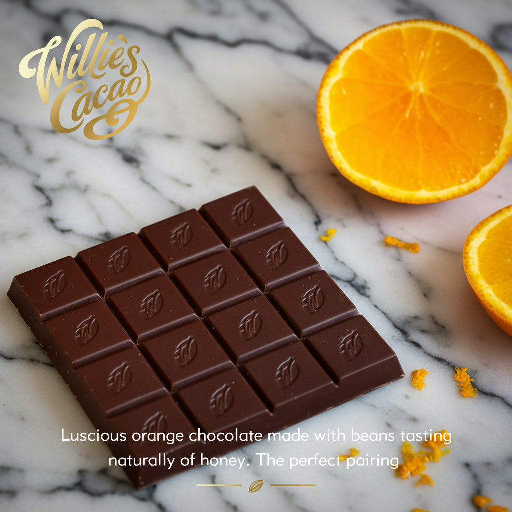 Chocolate bar with Willie's Cacao logo and a halved orange on a dark surface.