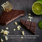 Willie's Cacao Ginger Lime 70% Dark Chocolate bar broken open with crystallized ginger pieces and fresh lime on dark slate surface
