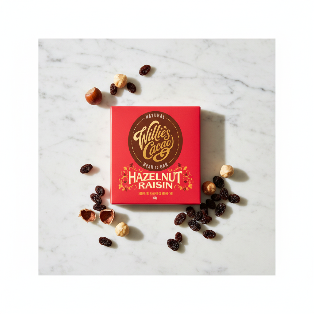 Willie's Cacao 70% Dark Chocolate Hazelnut Raisin red box on white marble surface with whole hazelnuts and raisins, smooth simple and moreish, natural bean-to-bar, 50g