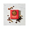 Willie's Cacao 70% Dark Chocolate Hazelnut Raisin red box on white marble surface with whole hazelnuts and raisins, smooth simple and moreish, natural bean-to-bar, 50g