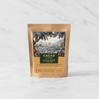 Cacao Adventures Ceremonial Grade Cacao Paste kraft pouch on white marble surface, single-origin Piura Peru, sugar-free and vegan