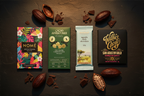 Four single-origin dark chocolate bars from Nomé, Cacao Adventures, French Broad Chocolate, and Willie's Cacao arranged on dark slate — the Cacao Voyage Dark Chocolate Deep Dive bundle