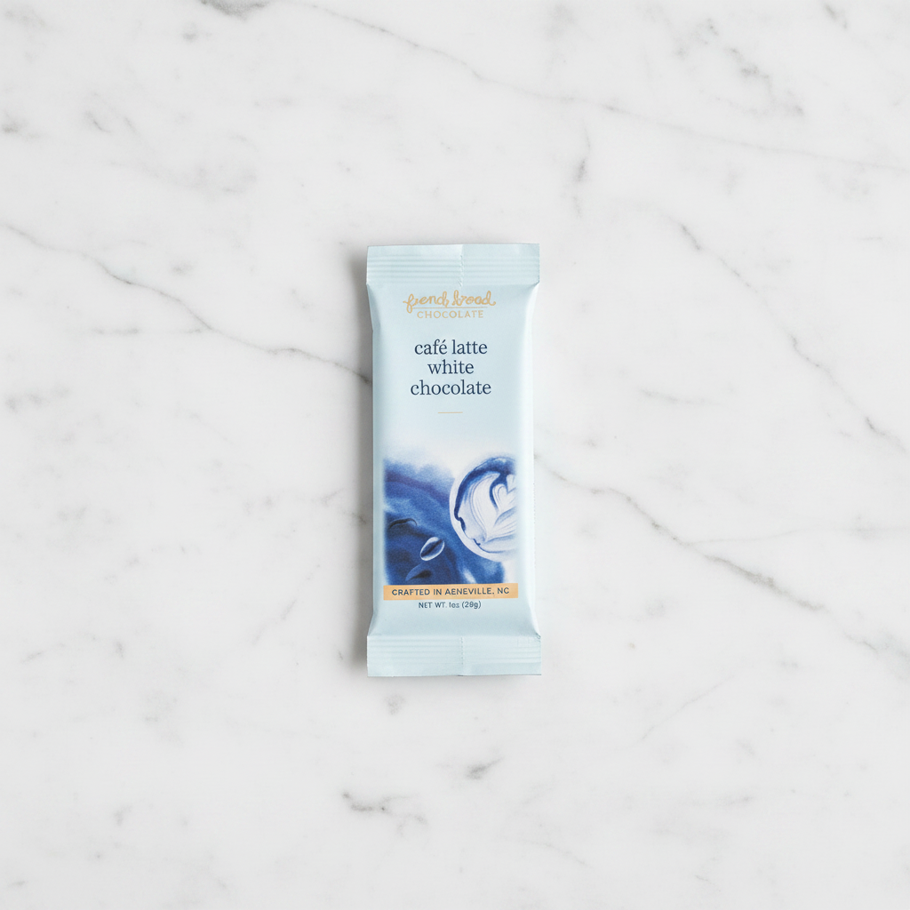French Broad Chocolate Café Latte White Chocolate light blue packaging on white marble surface, small batch craft, crafted in Asheville NC, 1oz 28g