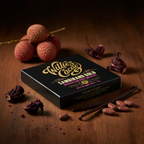 Willie's Cacao Sambirano Gold 71% Madagascan Dark Chocolate on dark wood with lychees, hibiscus flowers, vanilla pod, and raw cacao beans from the Sambirano Valley Madagascar, lively summer fruit notes